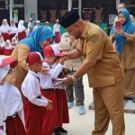Penyerahan-seragam-gratis-oleh-Wakil-Bupati-Siak-Syamsurizal-di-SD-Negeri-05-Kampung-Dalam,-Kota-Siak,-Kabupaten-Siak-(Dok.-Riau-Aktual)