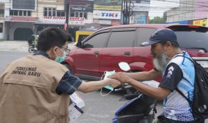 Petugas Diskes Pekanbaru memberikan masker gratis ke pengendara. (Dok. Riau Aktual)
