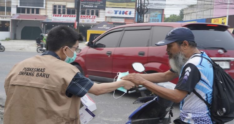 Petugas Diskes Pekanbaru memberikan masker gratis ke pengendara. (Dok. Riau Aktual)