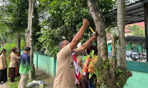 Pimpinan-Saka-Kalpataru-Tingkat-Cabang-Pekanbaru,-Langgeng-Wahyudi-mencabut-paku-dan-reklame-di-pohon-(Dok.-Riau-Aktual)
