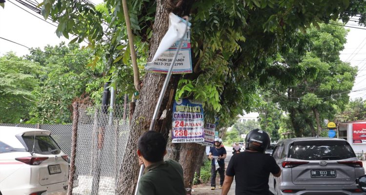 Tim-Bapenda-Kota-Pekanbaru,-melakukan-pembongkaran-iklan-yang-di-pasang-di-pohon.-(Dok.-Riau-Aktual)